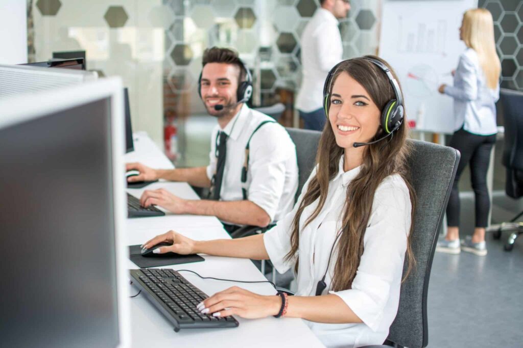 Truck dispatch company employees working behind computers with headsets on their heads