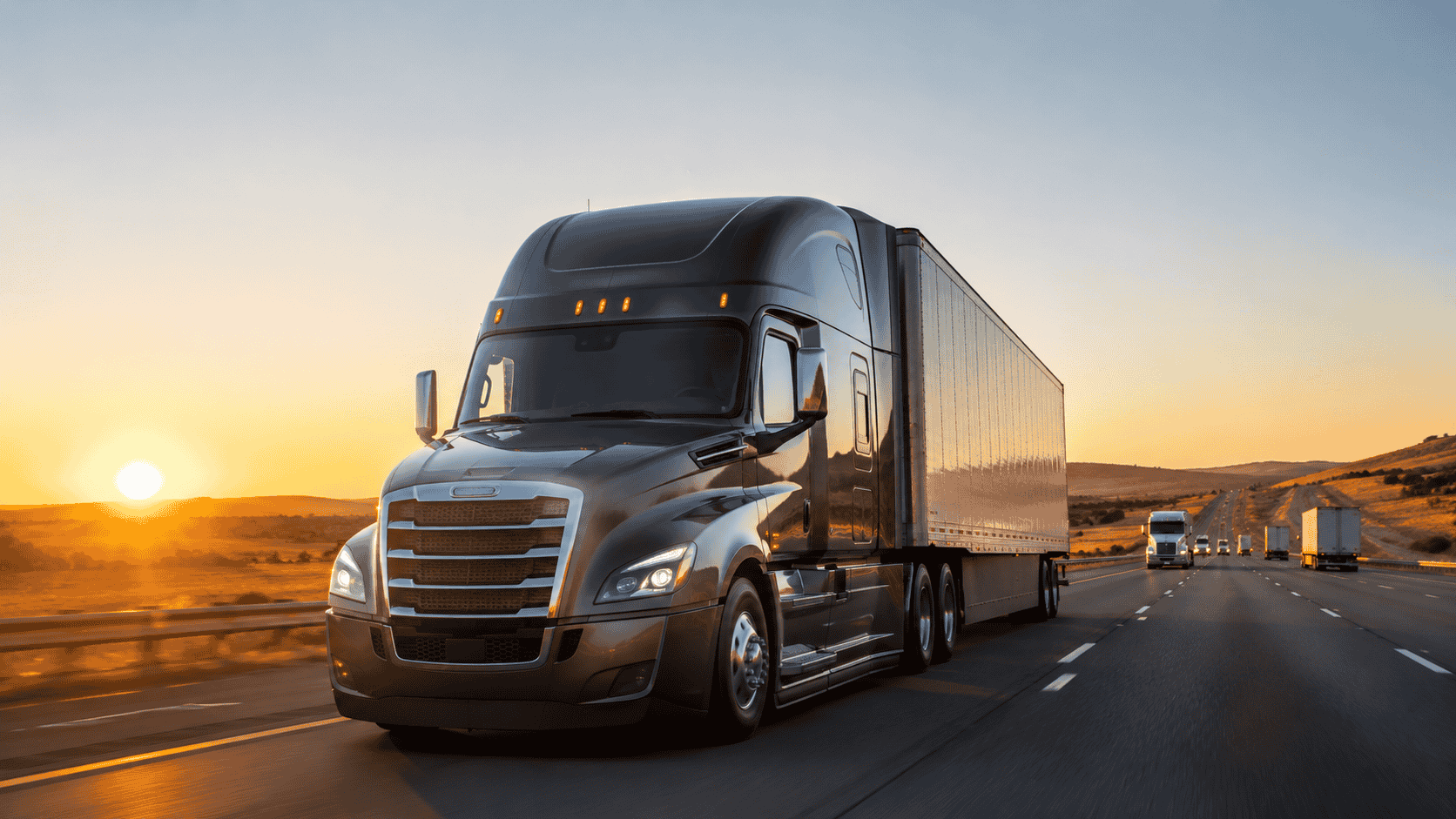 Semi-truck driving on an open highway at golden hour, illustrating the rising 2026 freight market for owner-operators